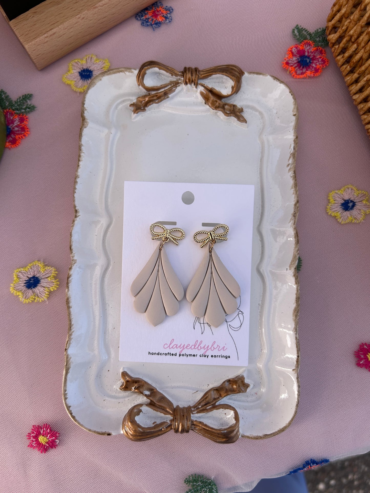 Off White Colored Dangle Earrings with a Gold Bow
