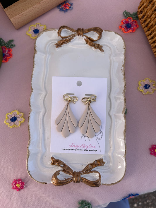 Off White Colored Dangle Earrings with a Gold Bow